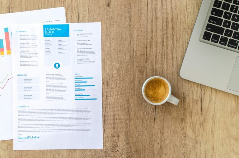 Picture of resume on table with coffee and laptop